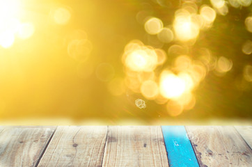 Nature autumn leaf bokeh with sun light on old empty wood table background.Product presentation in nature.