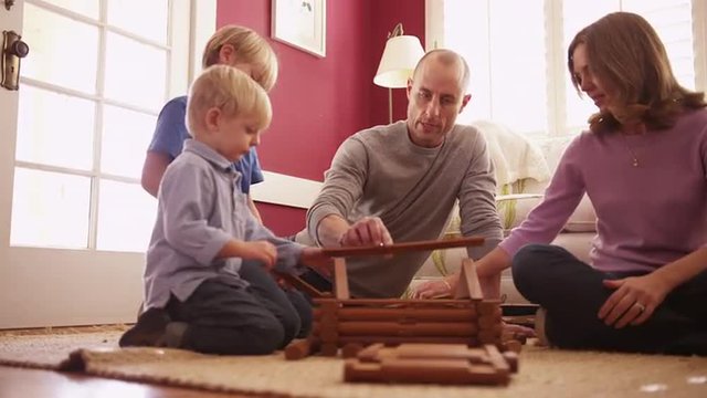 Lovely white family building a miniature wooden house