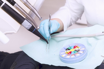 Dentist's hand with glove and dentist's tools