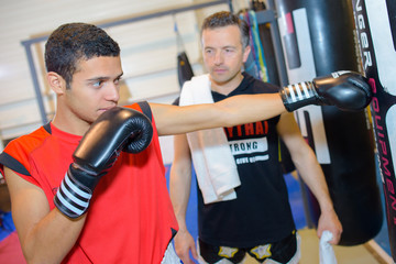 Young man in boxing training with instructor