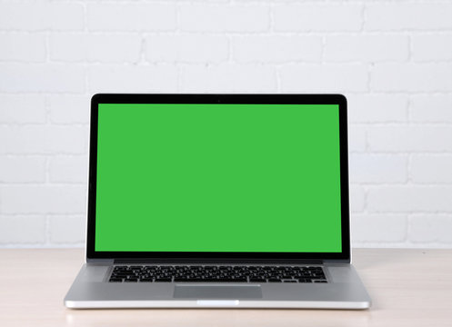 Modern laptop on table, on white wall background