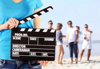 Operator holding clapperboard during the production of film outdoor