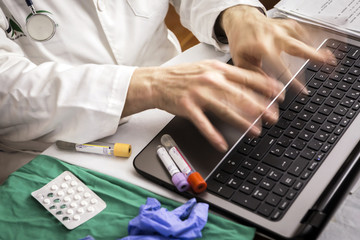 hands of doctor writing fast on laptop