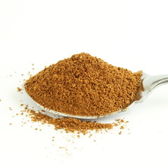 cinnamon powder closeup in spoon isolated on white background