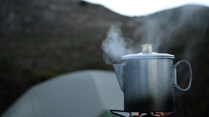 coffee percolating at the ocean-side campsite, with rack focus 