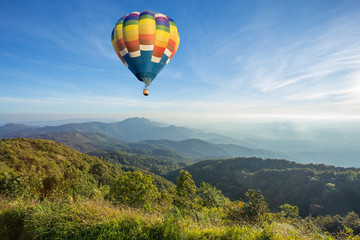 Fototapeta na wymiar Hot air balloon above high mountain at sunset