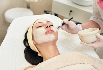 cosmetician applying facial mask