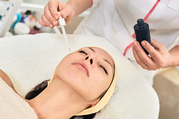 Obraz na płótnie Canvas applying cosmetic skin serum treatment