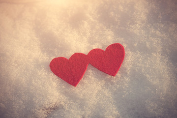 Red heart shapes on snow