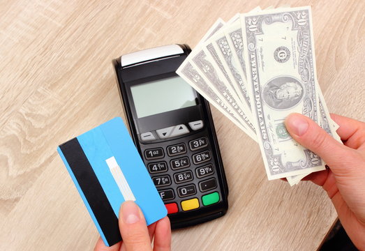 Currencies dollar with credit card and payment terminal in background, finance concept