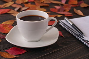 cup of aromatic coffee americano with notepad and pen