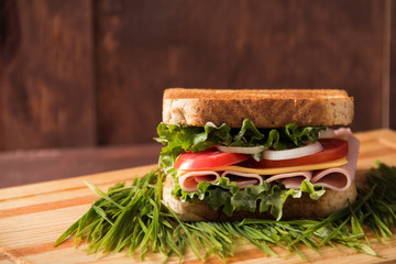 Sandwich and ice tea with grass, bread tomatos