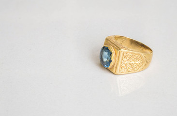 Closeup old blue pebble ring on blurred gray marble stone floor texture background