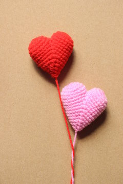 Red and pink love hearts on brown paper backgrounds, light soft tone, valentines day card concept.