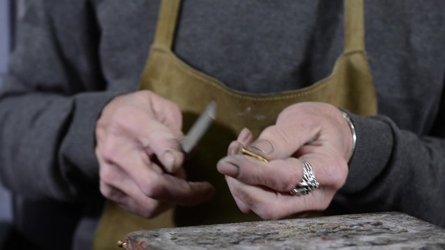 Craftsman jeweler creates a bracelet in his workshop