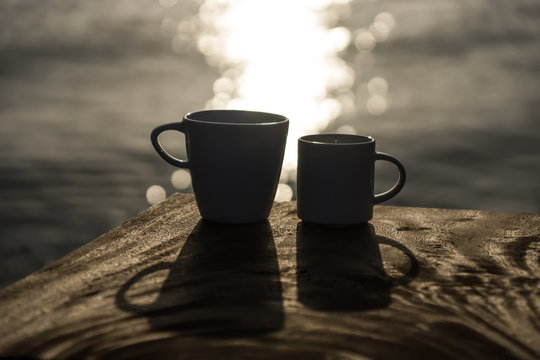 Silhouettes of morning coffee on the lake.