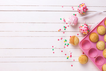 Colorful  cake pops on white wooden background.