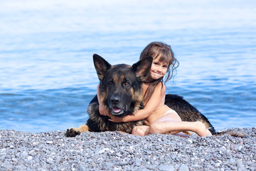 girl sitting on the bank with a dog