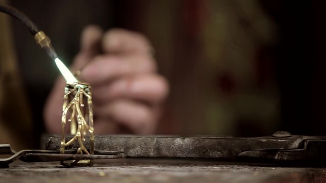 Craftsman jeweler creates a bracelet in his workshop