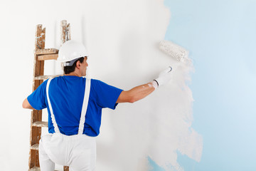 painter painting a wall with paint roller - 101692686