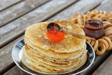 A stack of delicious, pancakes with red caviar laid out on the p