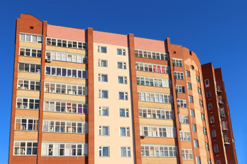 Fototapeta na wymiar Top of high brick residential building with loggies 