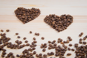 coffee in the shape of a heart on a wooden desk surface. coffee in the shape of a heart. Two hearts of coffee
