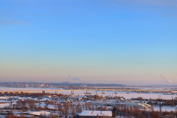 Bridge over frozen river and panoramic view of city 