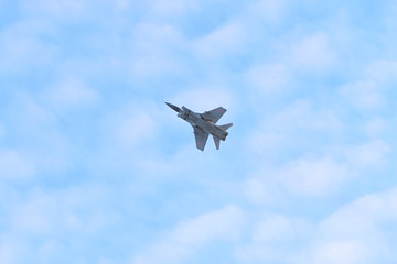Russian military aircraft MiG-29 flies in blue sky 
