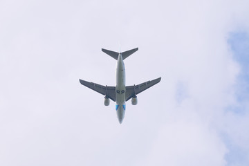 Under view of modern passenger airliner in blue sky