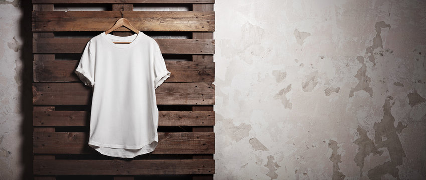 Photo White Tshirt  Hanging In Front Of Concrete Wall. Wide