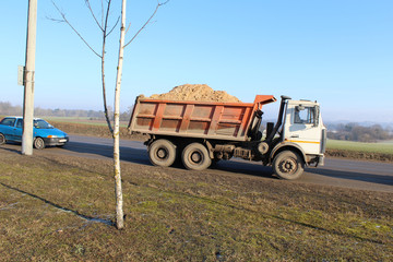 Truck with sand on the road