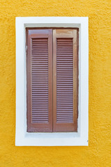 Big brown window on the yellow wall