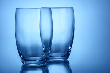 Two empty clean glasses for water or alcohol blue color