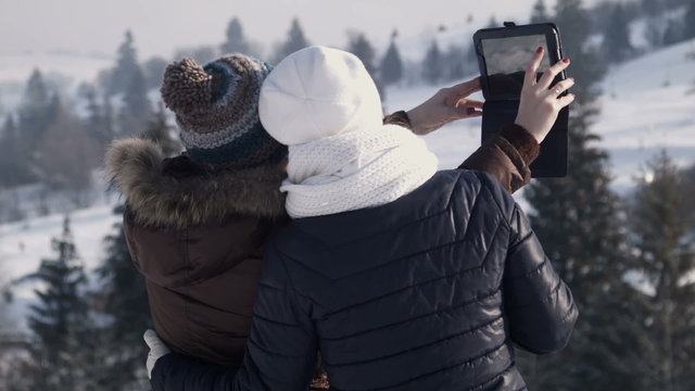 girlfriends do selfie on the mountain using tablet