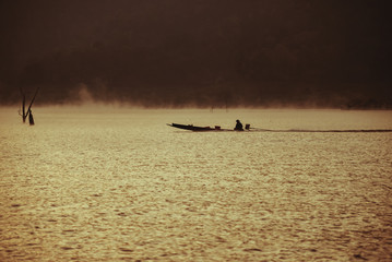 Early morning sunrise, boating on the lake in a huge fog