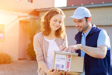 Young attractive woman receiving parcel at home