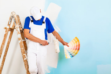 painter with paintroller showing a color palette © guerrieroale