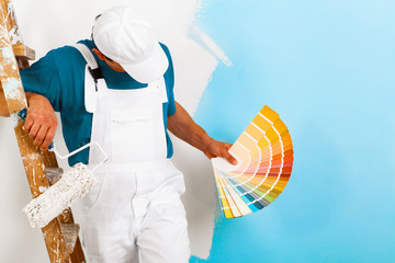 painter  with paintroller showing a color palette - obrazy, fototapety, plakaty