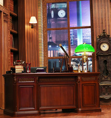 Classical library room with leather armchair, wooden table and bookcase