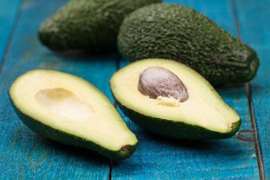 fresh avocados on wooden background. Healthy food, diet. Vegetarian.