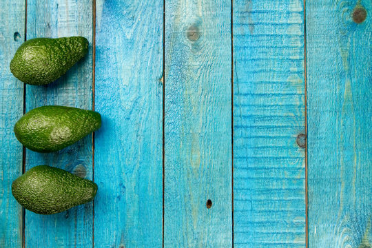 fresh avocados on wooden background. Healthy food, diet. Vegetarian.