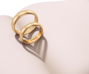 Wedding rings casting heart shaped shadow