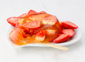 gelatin dessert and fresh strawberries on white marble