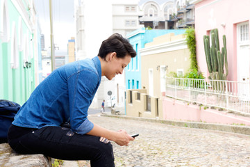 Young woman sitting outside with cell phone