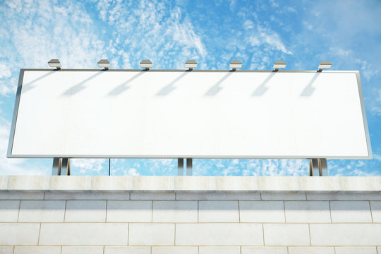 Blank White Billboard On The Top Of Building At Blue Sky Backgro