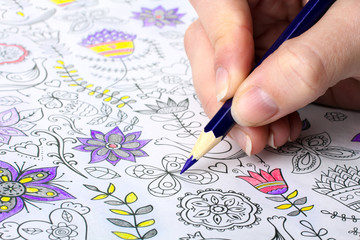 colorer - antistress with colored pencils.The woman draws thereby relieves stress