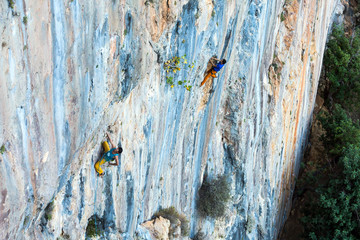 High Unusual Color rocky Wall and two Climbers ascending