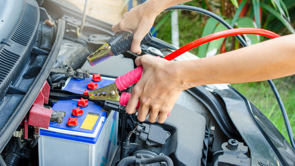 Hand holding battery charger, maintenance car by yoursalf