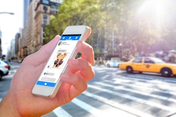 Composite image of hand holding smartphone